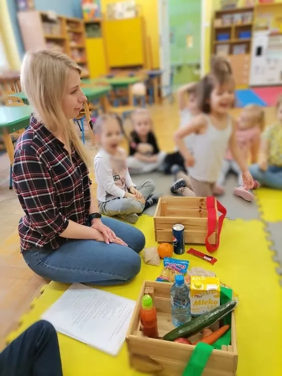 Dietetyk prowadzi warsztaty o zdrowym żywieniu dla grupy dzieci w przedszkolu.
